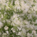 A mixture of finely chopped green onions and garlic.